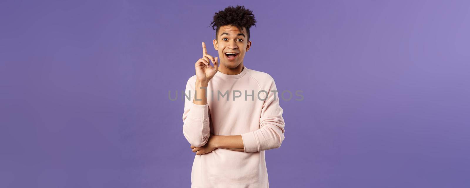 Portrait of excited happy man finally understood something, have great idea, express suggestion or opinion, raise finger up eureka gesture, smiling upbeat got nice plan, purple background.