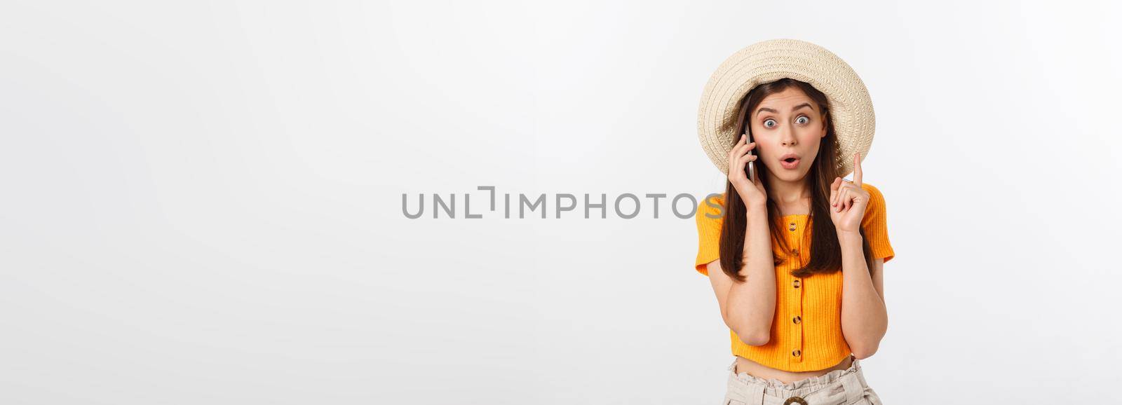 Picture of surprised voyage girl looking shock while holding phone in hands isolated over grey background.
