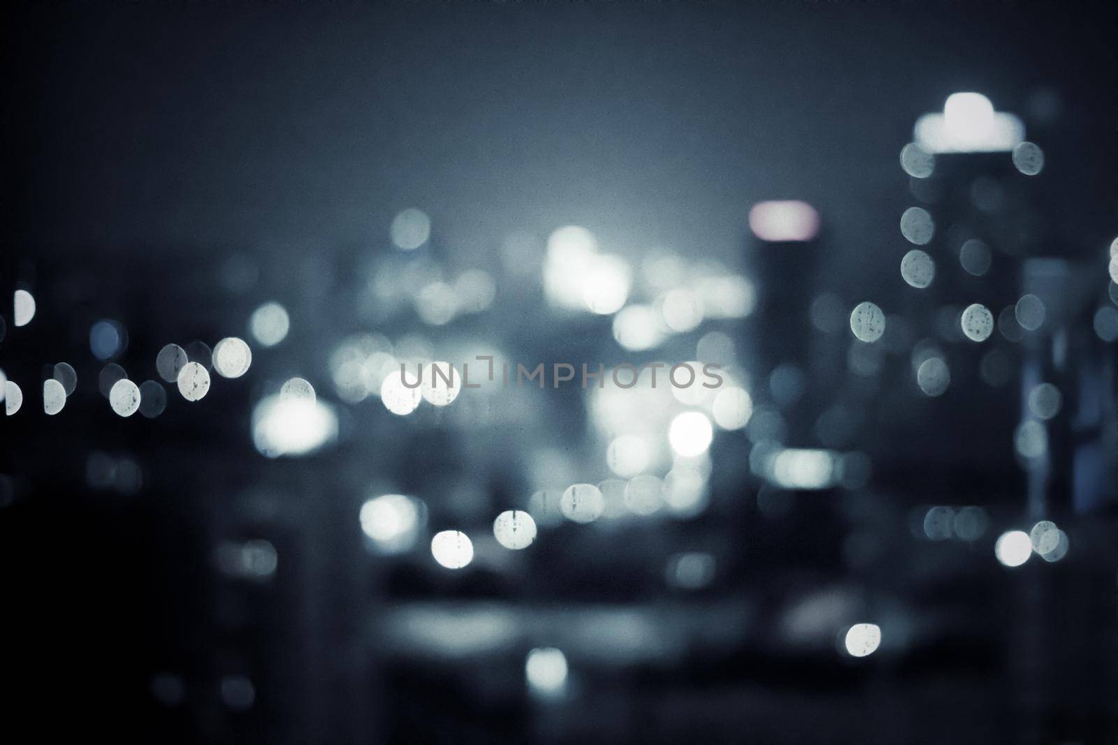 Big metropolitan city lights at night, blurry background - night life, abstract background and modern dark tones concept