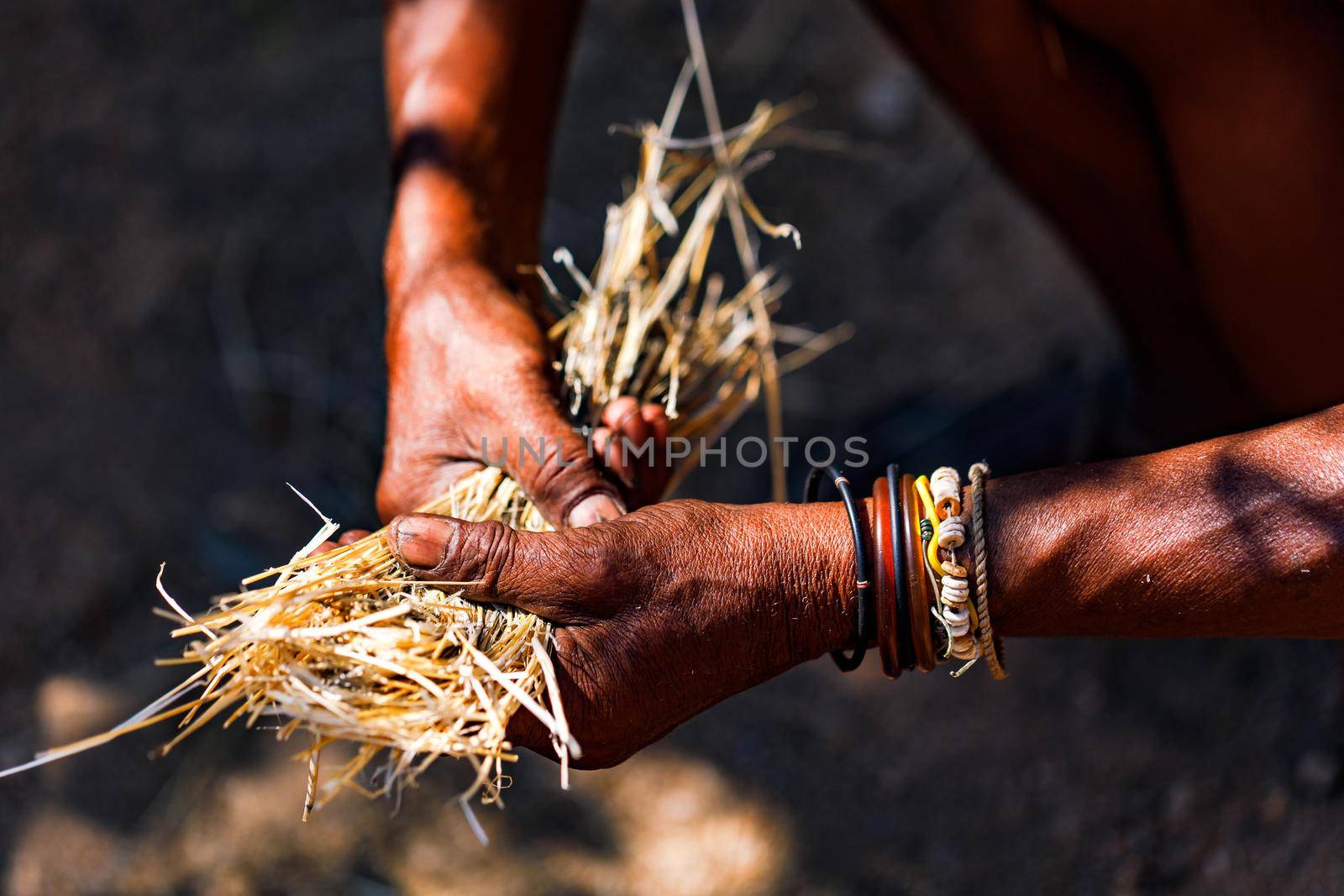 Working hands in Africa naturally make fire with straw