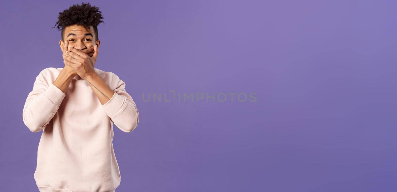 Portrait of amused, funny and carefree male student fooling around during class lecture, giggle, trying not laugh out loud so shut his mouth with hands, chuckle over hilarious joke by Benzoix