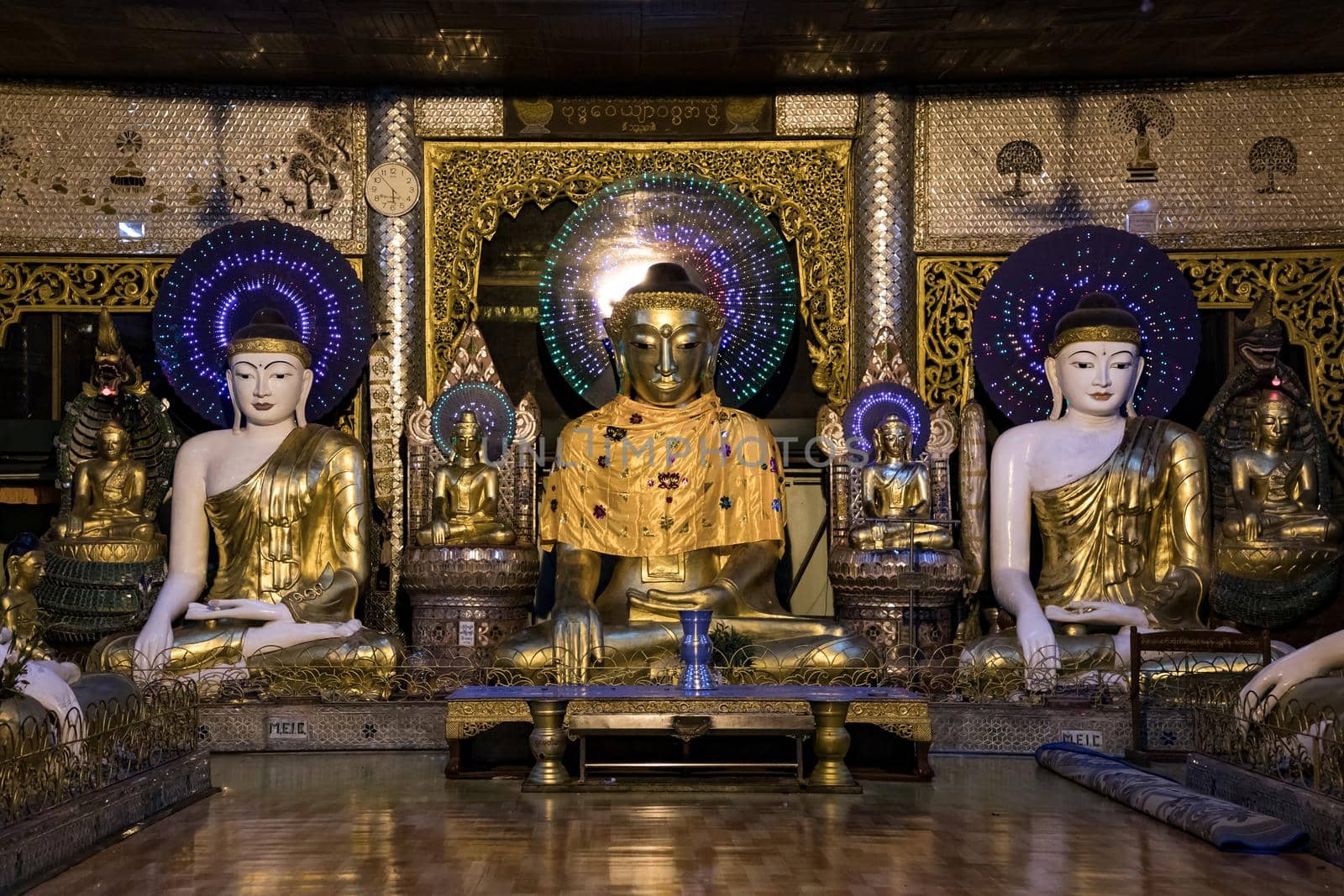 The kitschy Buddha statues in the Shwedagon Pagone in Myanmar are brightly lit