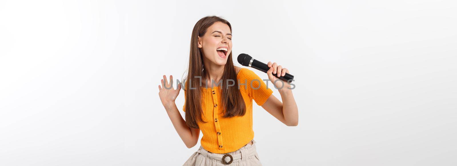 Young pretty woman happy and motivated, singing a song with a microphone, presenting an event or having a party, enjoy the moment by Benzoix