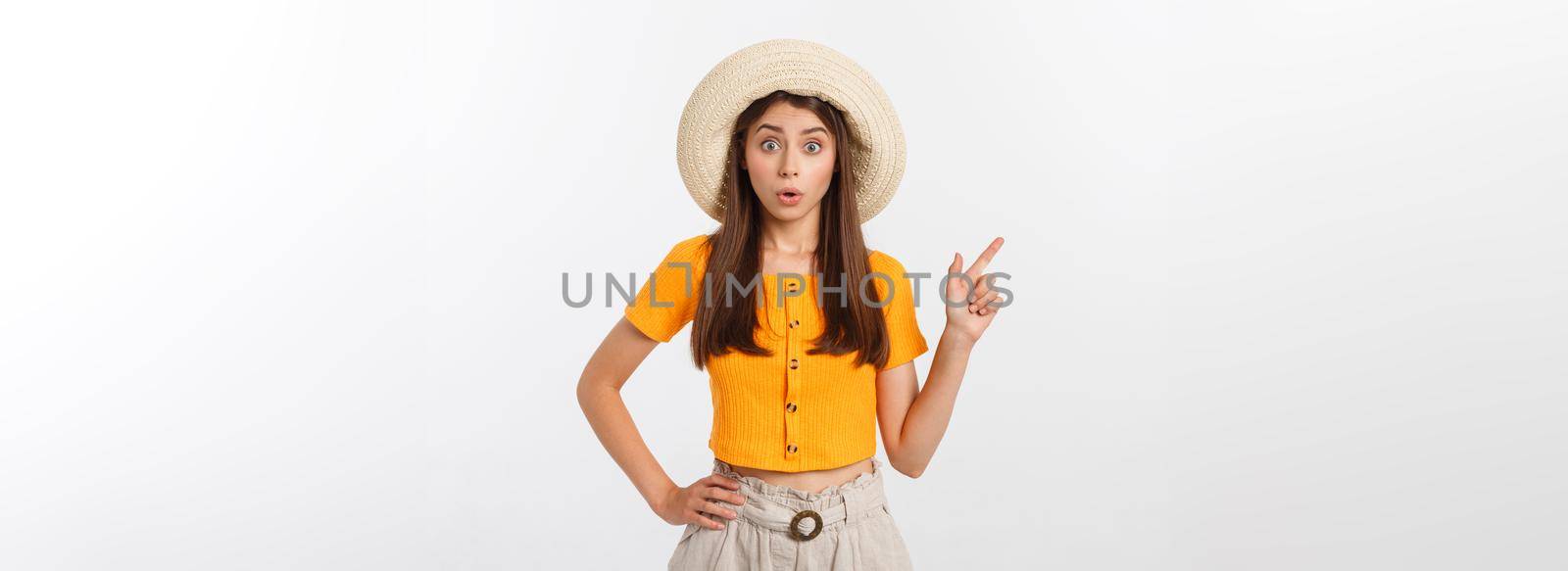 Teenager girl on summer vacation surprised and pointing finger on copy space over isolated white background. by Benzoix