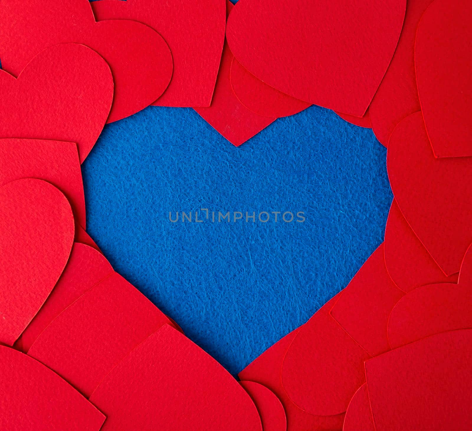 Paper cut red hearts frame on blue textured background with copy space. Concept image. Valentine's day, mother's day, birthday greeting cards, invitation, celebration