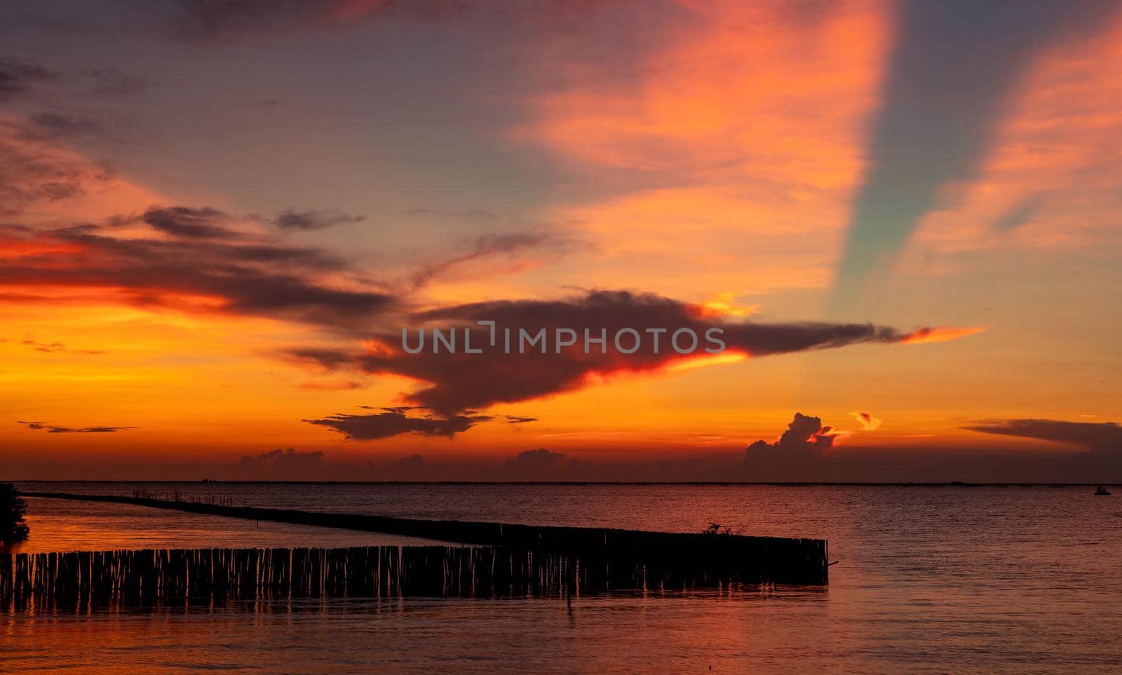 Beautiful red and orange sunset sky over the tropical sea. Red sunset sky. Skyline at the sea. Tropical sea. Scenic view of sunset sky. Calm ocean. Seascape. Art picture of clouds layer on sunset sky.