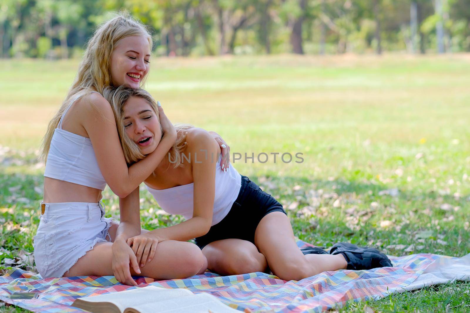 Young teen girls play fun together in the garden with action of happiness and they hug friend with smile.