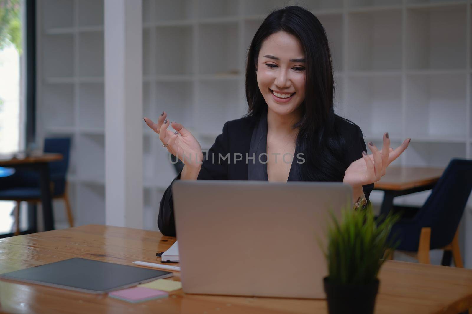 During a video conversation with her business team, a businesswoman discusses the stock market and the concept of working from home.