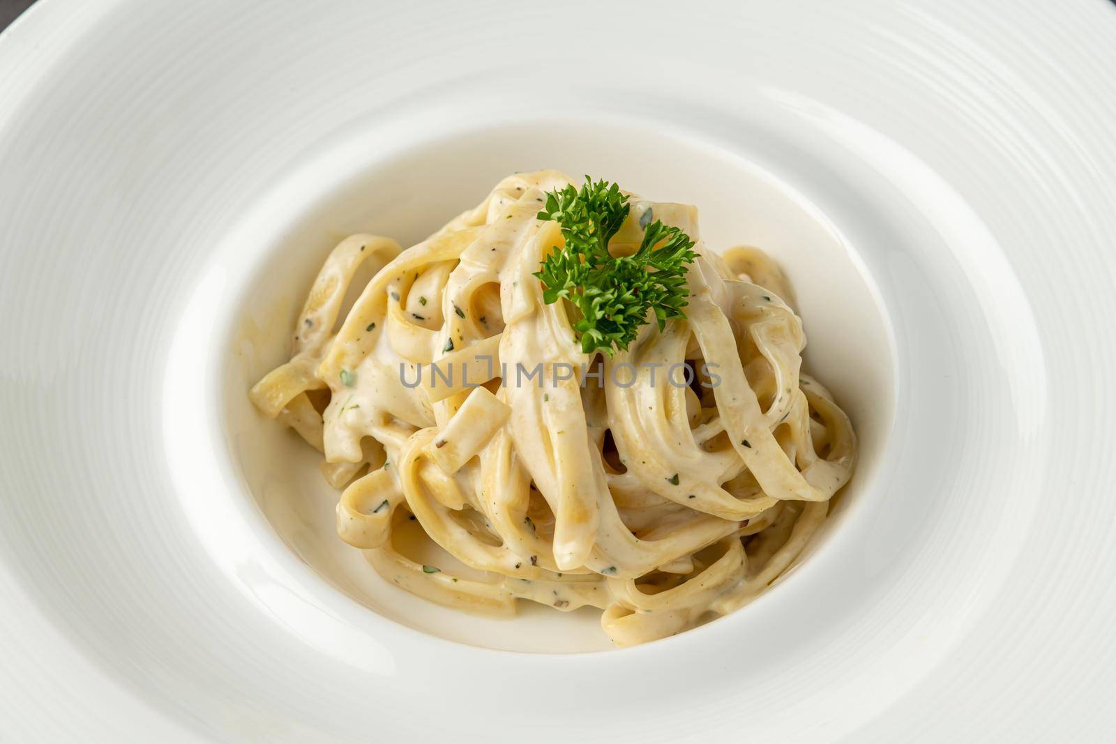 Freshly made fettucini alfredo on a white porcelain plate