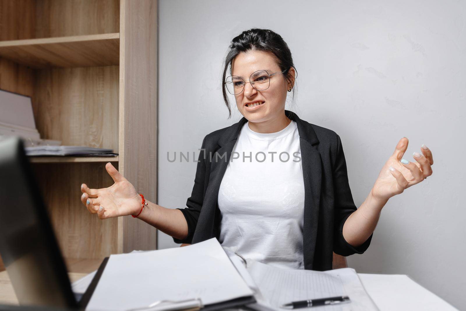 young attractive businesswoman frustrated and desperate expression in the office working on a laptop computer in stress at work concept screaming angry with sad.