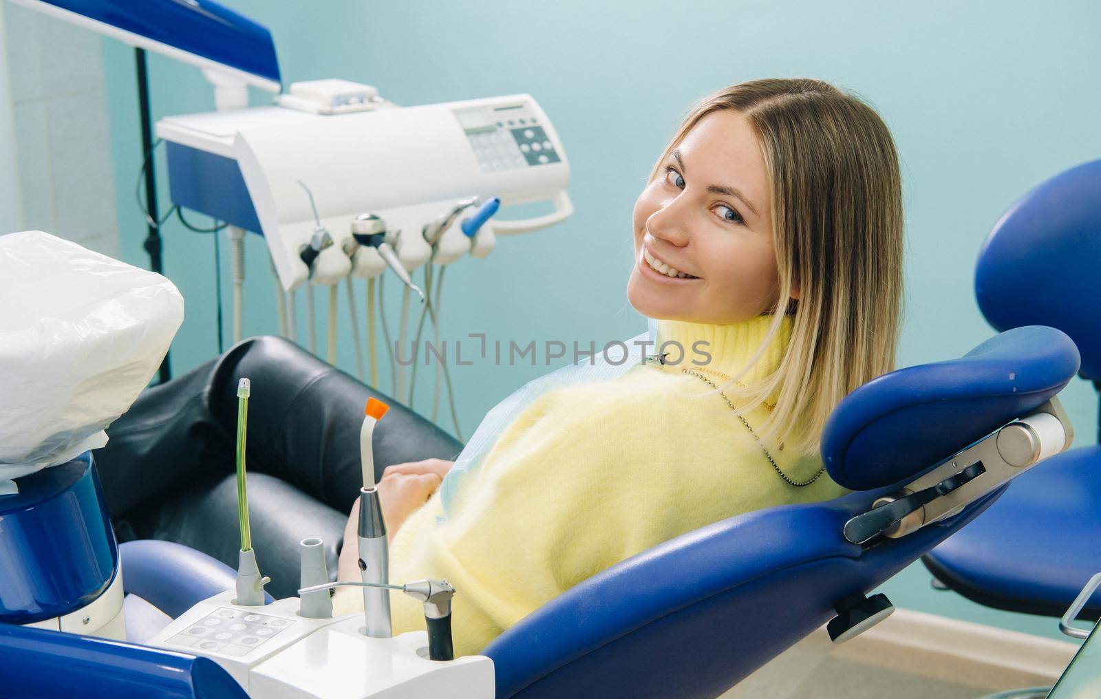 The girl smiles at the dentist and looks at her.