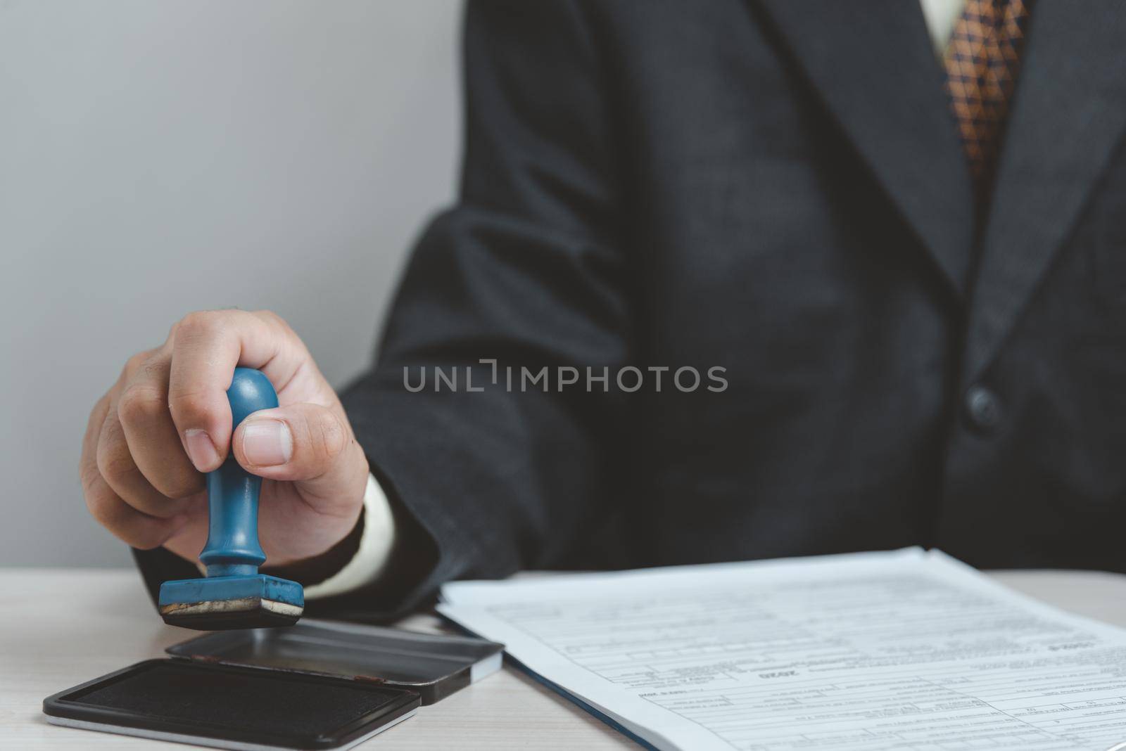 Man stamping approval of work finance banking or investment marketing documents on desk. by aoo3771