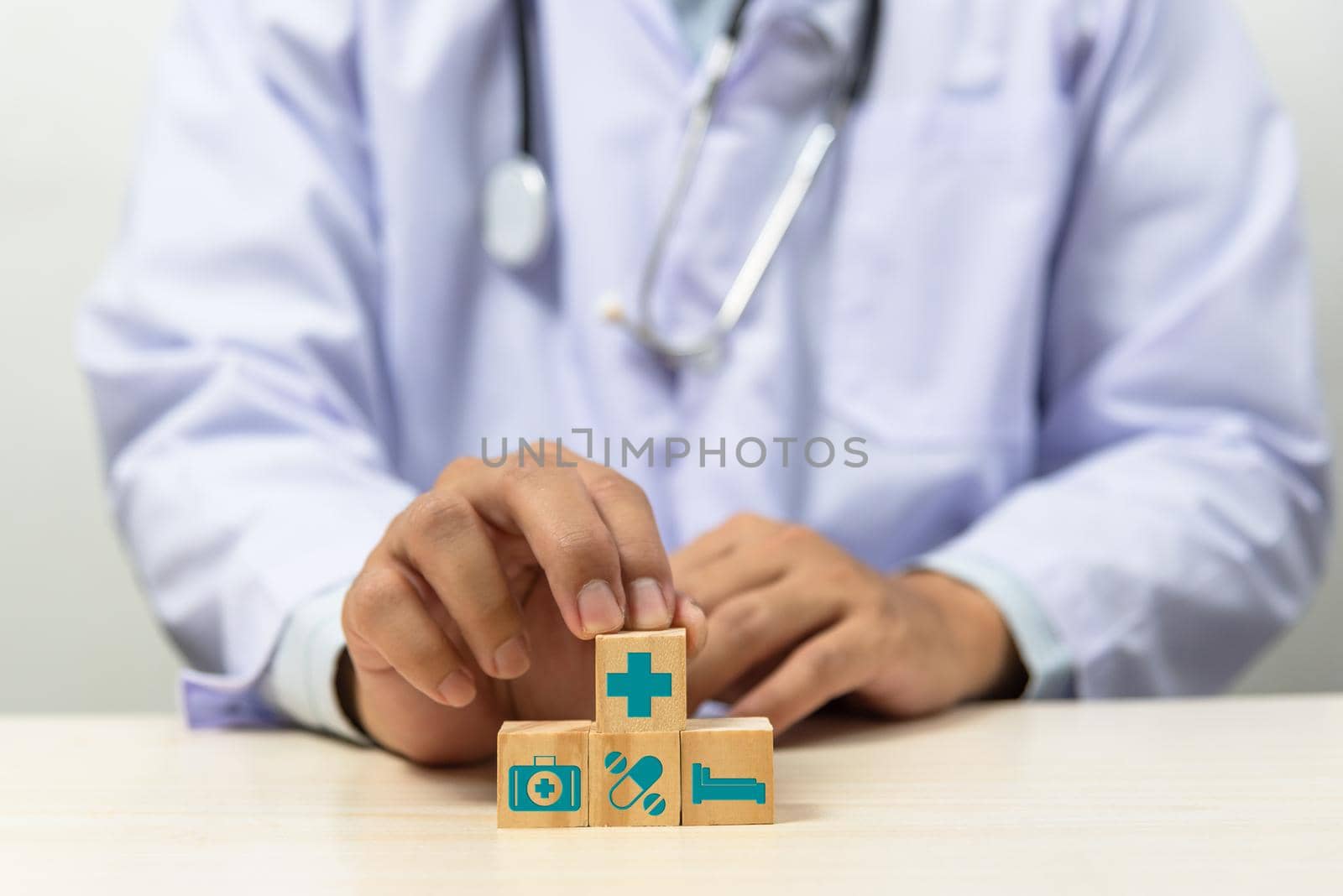 Hand holding wooden cubes block with insurance health car medical symbol on background and copy space. by aoo3771