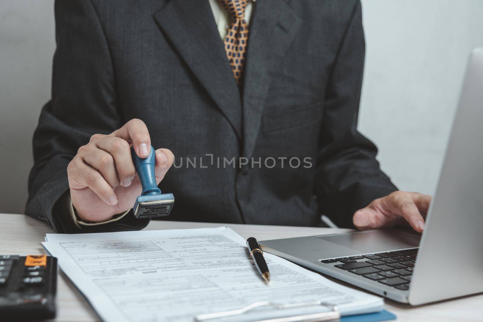 Man stamping approval of work finance banking or investment marketing documents on desk. by aoo3771