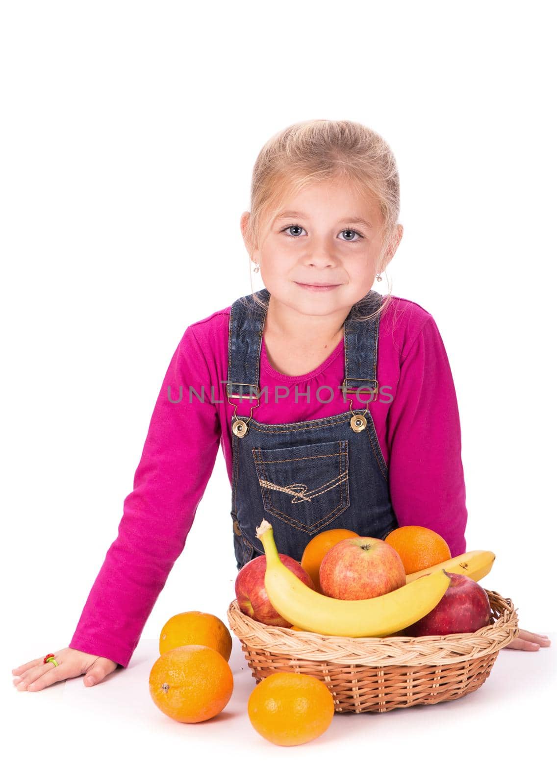 Close-up portrait of a little girl holding fruits - apples and pear.