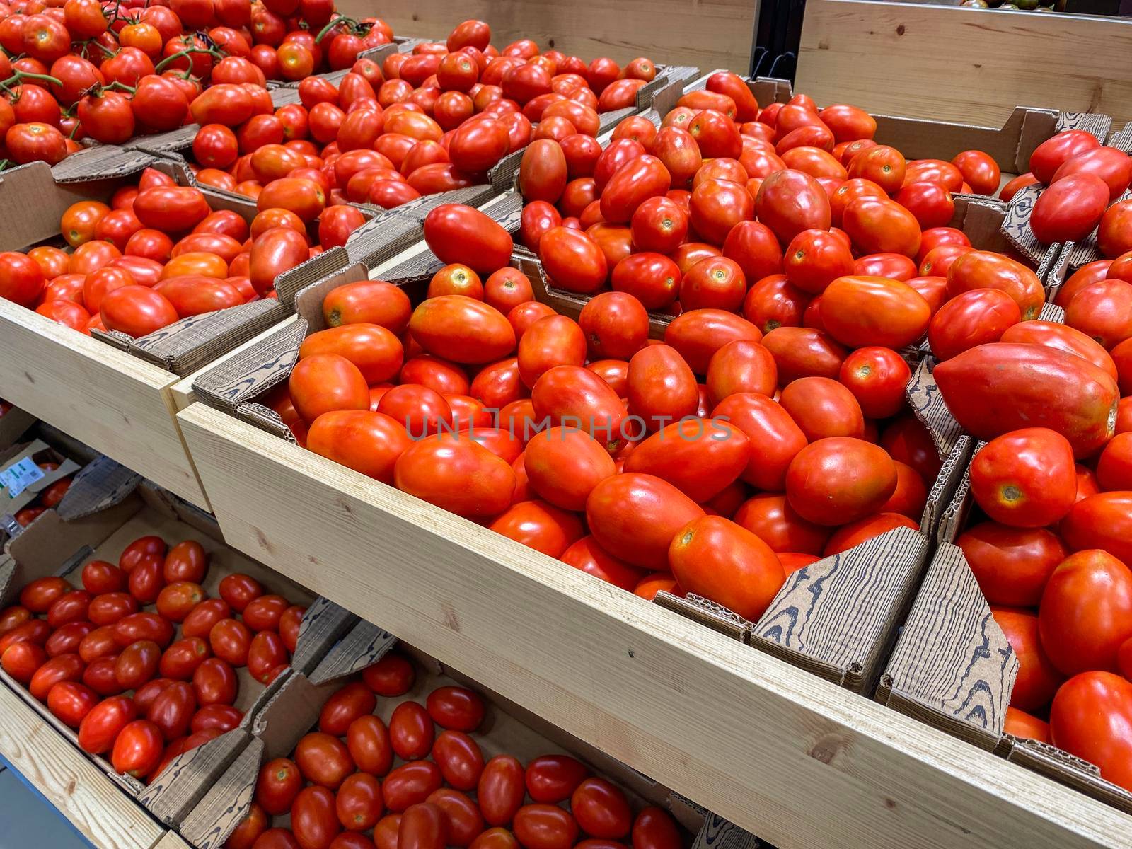 Fresh organic red pear tomatoes in a market or supermarket. Tomatoes in boxes in a food store