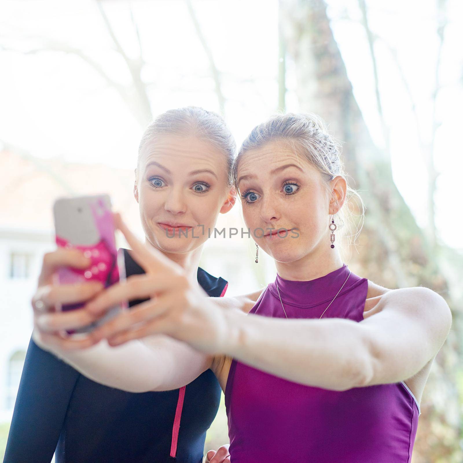 Get fit and have fun while doing it. two sporty young women taking a selfie after their workout. by YuriArcurs