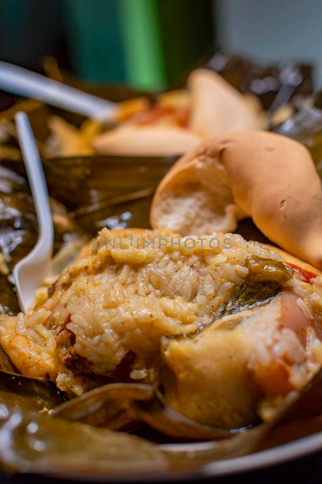 Nacatamales with bread served on table, Traditional Hallaca served. Close up of two Nacatamales in banana leaf served on table. Two Nacatamales served in a banana leaf on a wooden table by isaiphoto