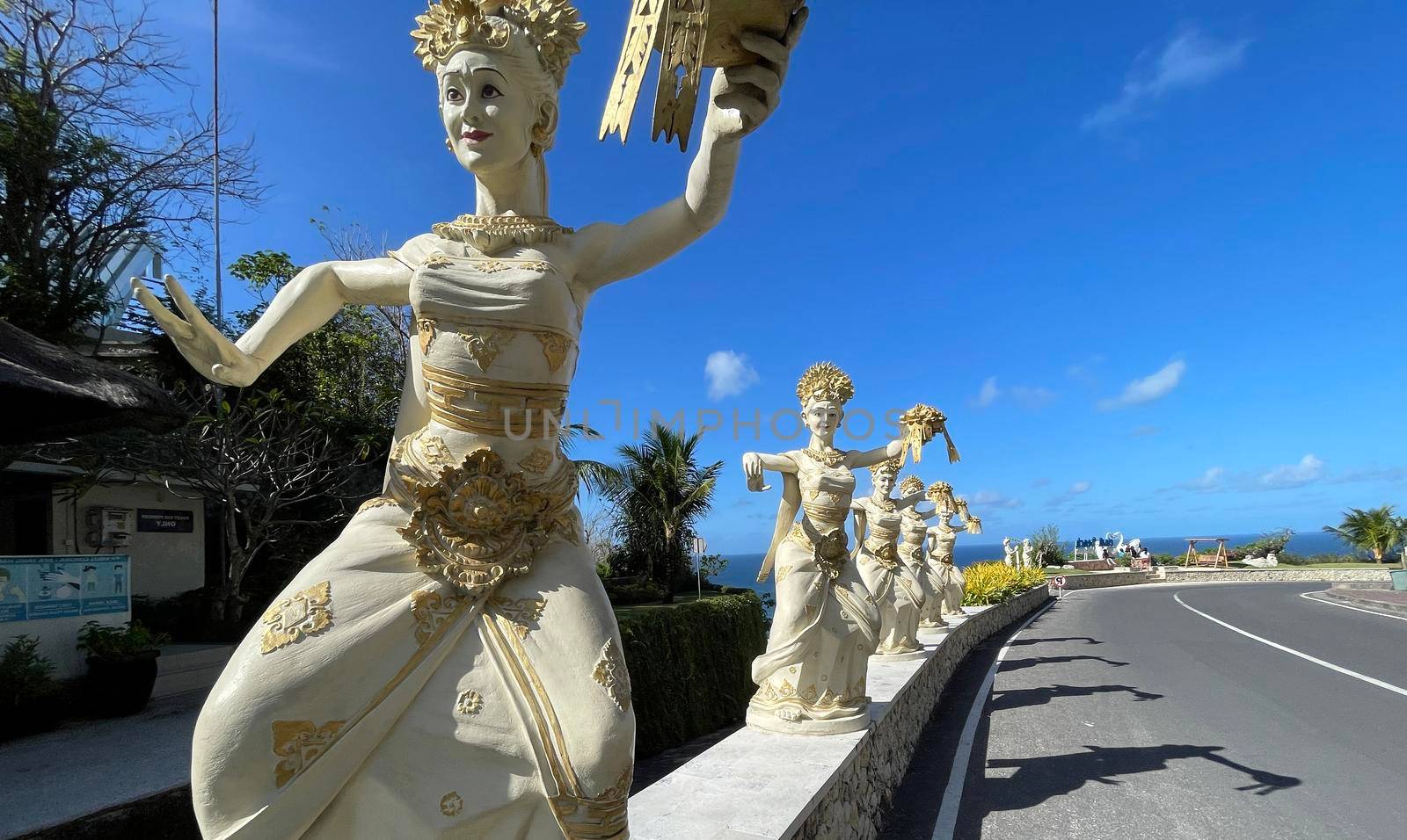 Bali, Indonesia - 06 July 2022: Sculpture of Balinese dancers at the entrance to Pantai Melasti Beach under the blue sky