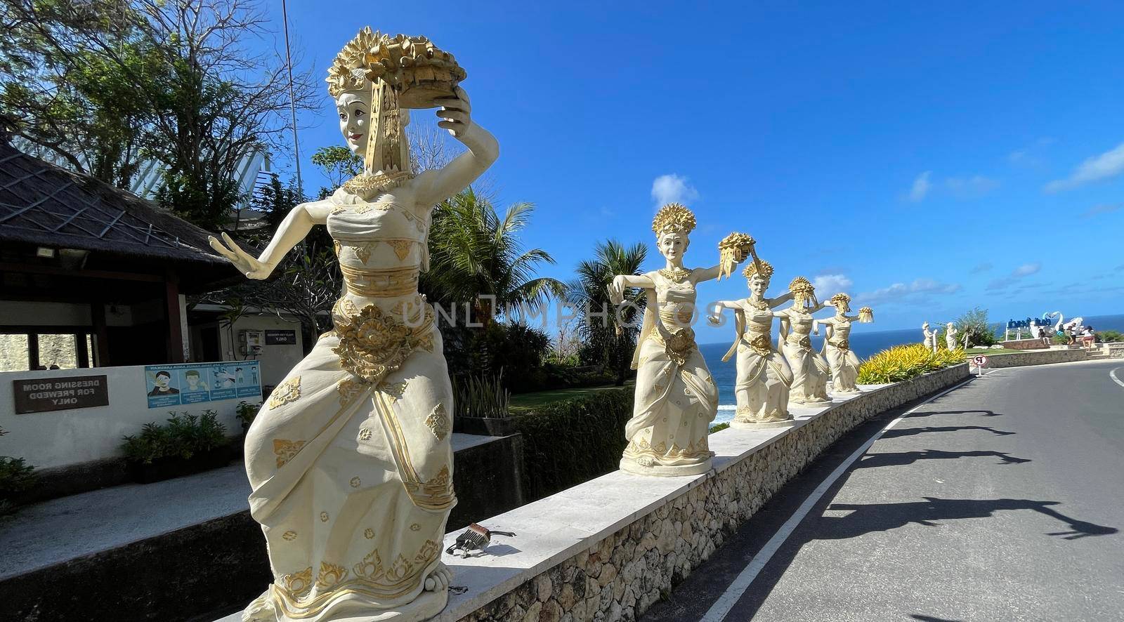 Bali, Indonesia - 06 July 2022: Sculpture of Balinese dancers at the entrance to Pantai Melasti Beach under the blue sky