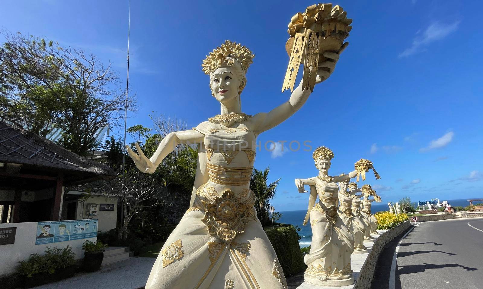 Bali, Indonesia - 06 July 2022: Sculpture of Balinese dancers at the entrance to Pantai Melasti Beach under the blue sky