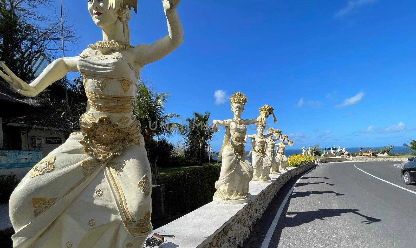 Bali, Indonesia - 06 July 2022: Sculpture of Balinese dancers at the entrance to Pantai Melasti Beach under the blue sky