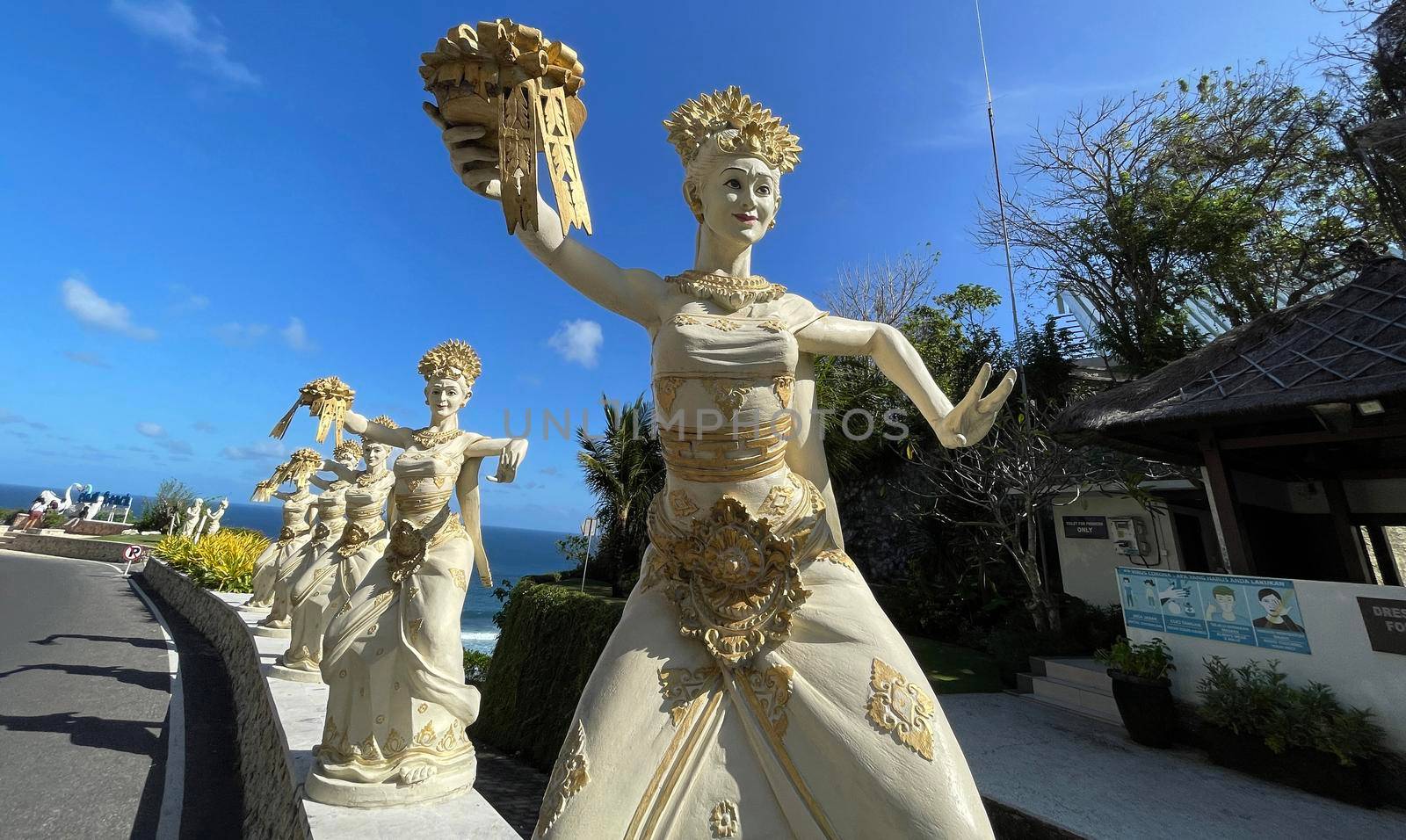 Bali, Indonesia - 06 July 2022: Sculpture of Balinese dancers at the entrance to Pantai Melasti Beach under the blue sky