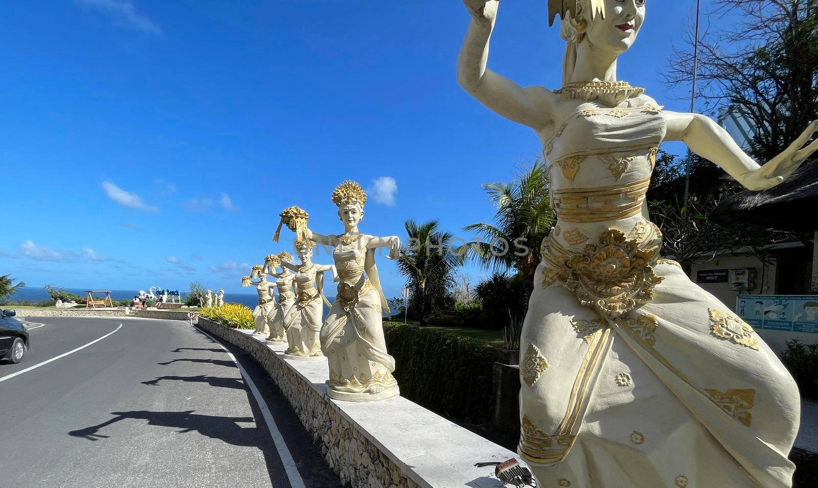 Bali, Indonesia - 06 July 2022: Sculpture of Balinese dancers at the entrance to Pantai Melasti Beach under the blue sky