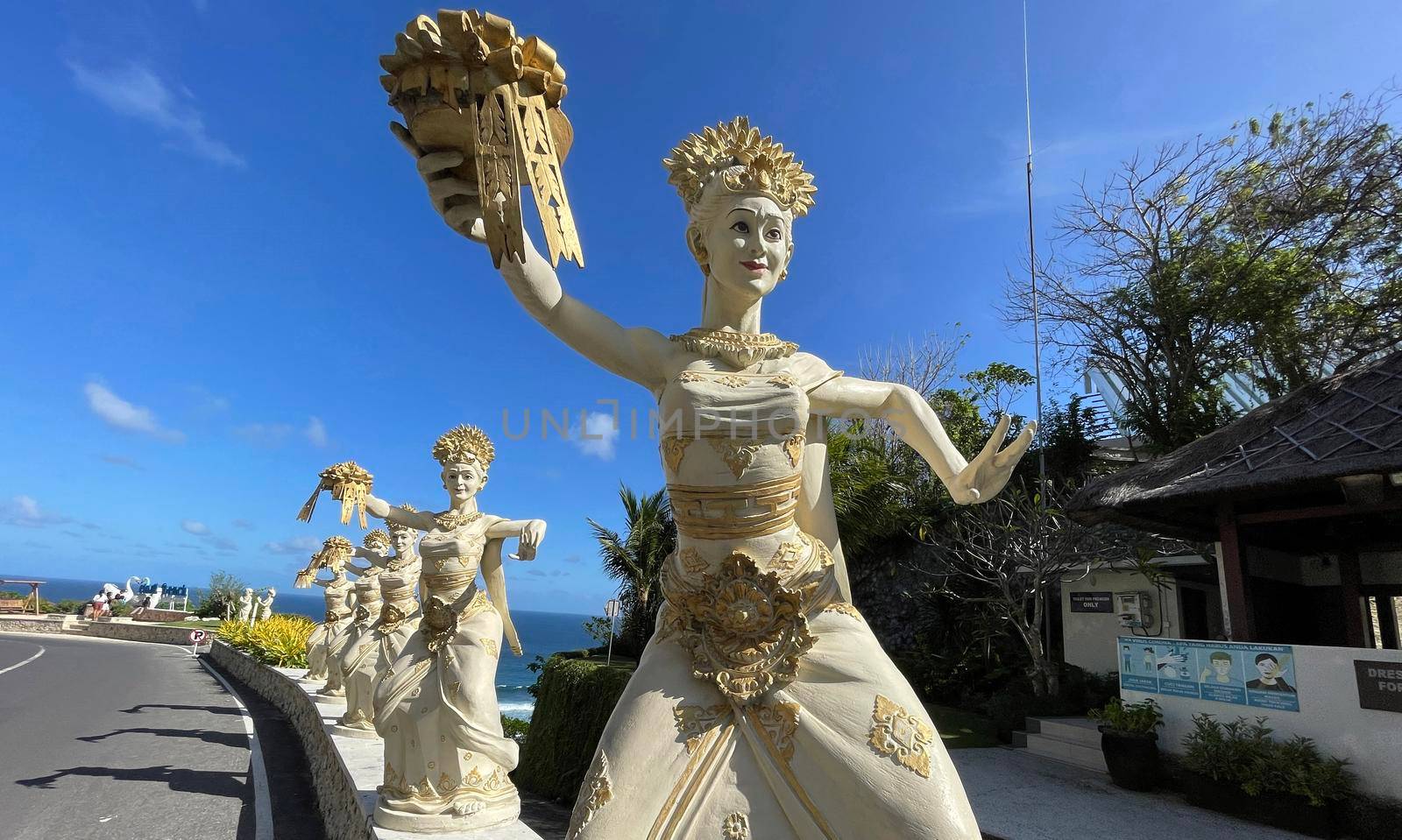 Bali, Indonesia - 06 July 2022: Sculpture of Balinese dancers at the entrance to Pantai Melasti Beach under the blue sky