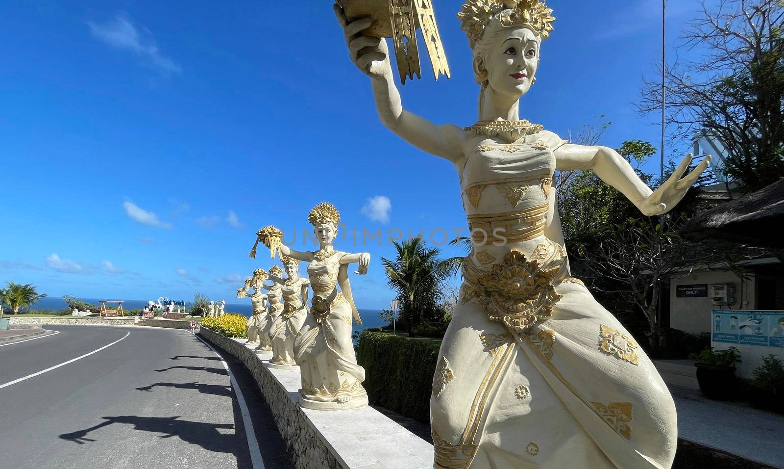 Bali, Indonesia - 06 July 2022: Sculpture of Balinese dancers at the entrance to Pantai Melasti Beach under the blue sky