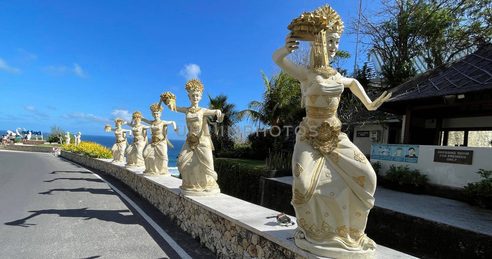 Bali, Indonesia - 06 July 2022: Sculpture of Balinese dancers at the entrance to Pantai Melasti Beach under the blue sky