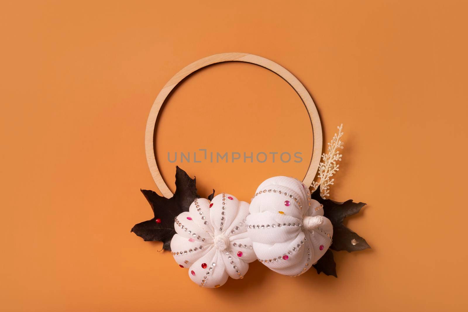 White decorative textile pumpkins with shiny stones and wooden frame for your text. Autumn harvest and thanksgiving day concept.