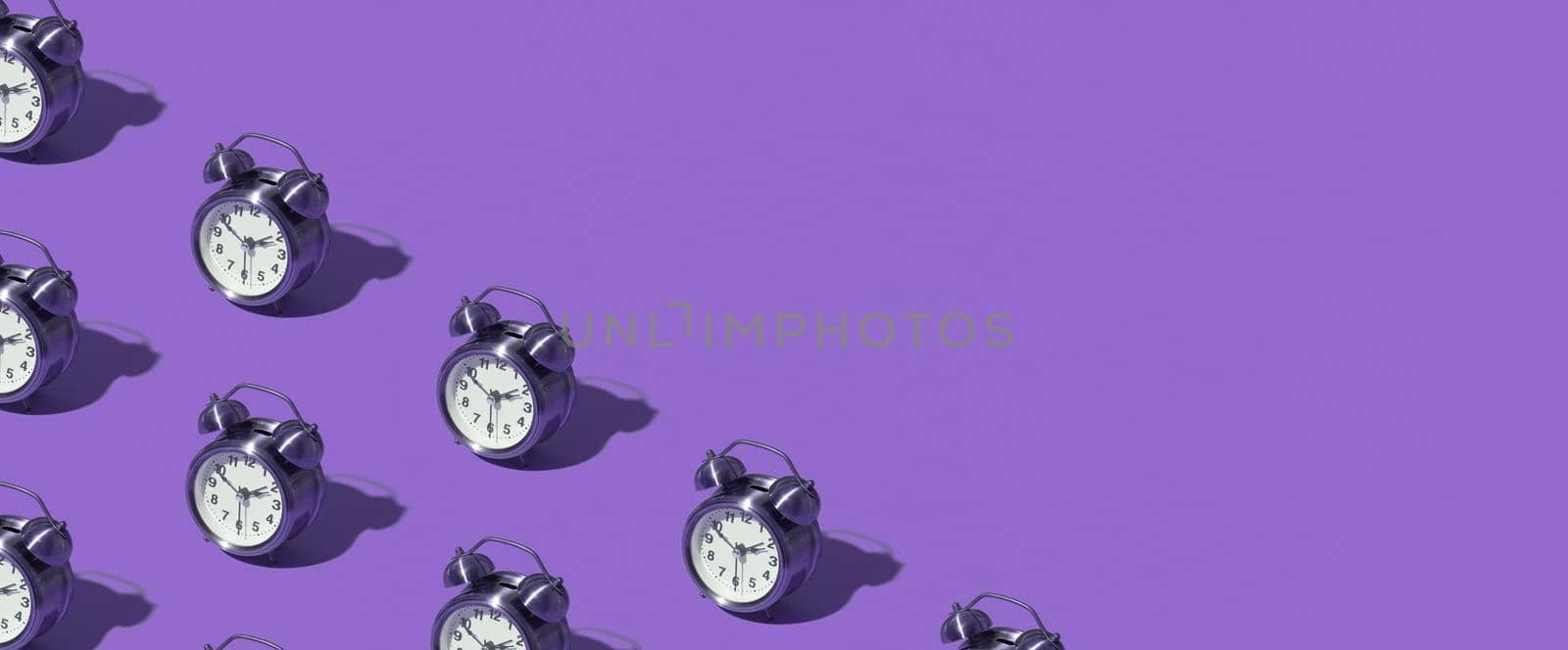 Pattern of an alarm clock on a colored background. Monochrome time concept. Banner format. by ssvimaliss