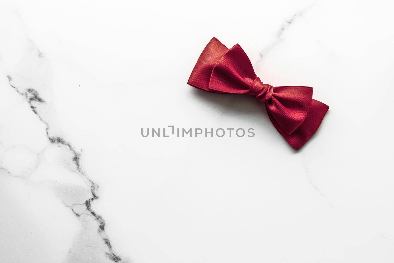 Holiday gift, decoration and sale promotion concept - Bordeaux silk ribbon on marble background, flatlay