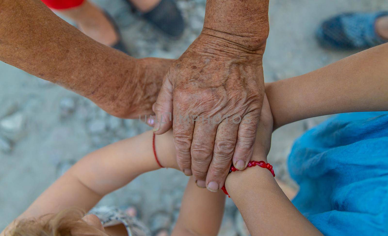Grandmother and grandchildren friends hands together. Selective focus. People.