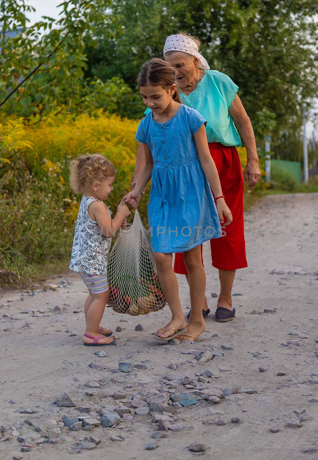 Children and grandmother carry vegetables in a bag. Selective focus. Food.