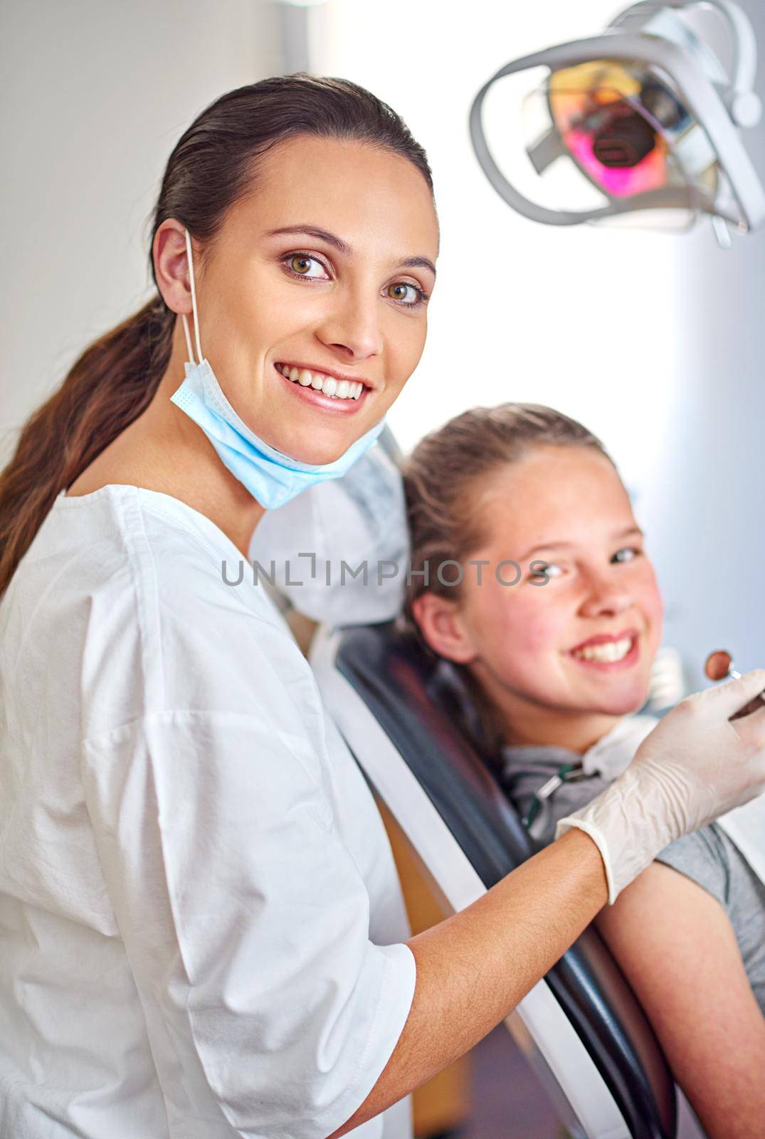 Always professional. Portrait of an attractive female dentist and her child patient. by YuriArcurs