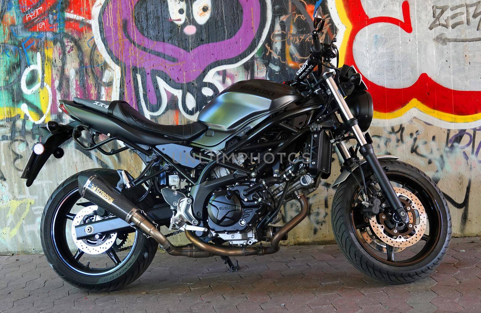 Rheine, NRW, Germany - August 24 2022 A black Suzuki SV650 motorcycle standing in front of a graffiti wall