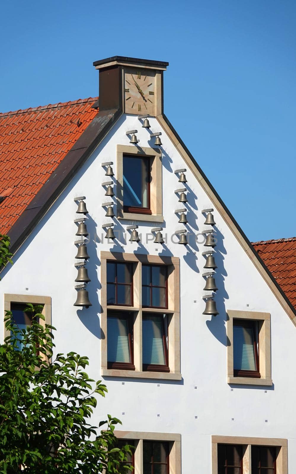 Rheine, NRW, Germany - August 24 2022 On the gable of this house in Rheine is a carillon attached to the wall. It's called 'Glockenhaus' (Bell-house)