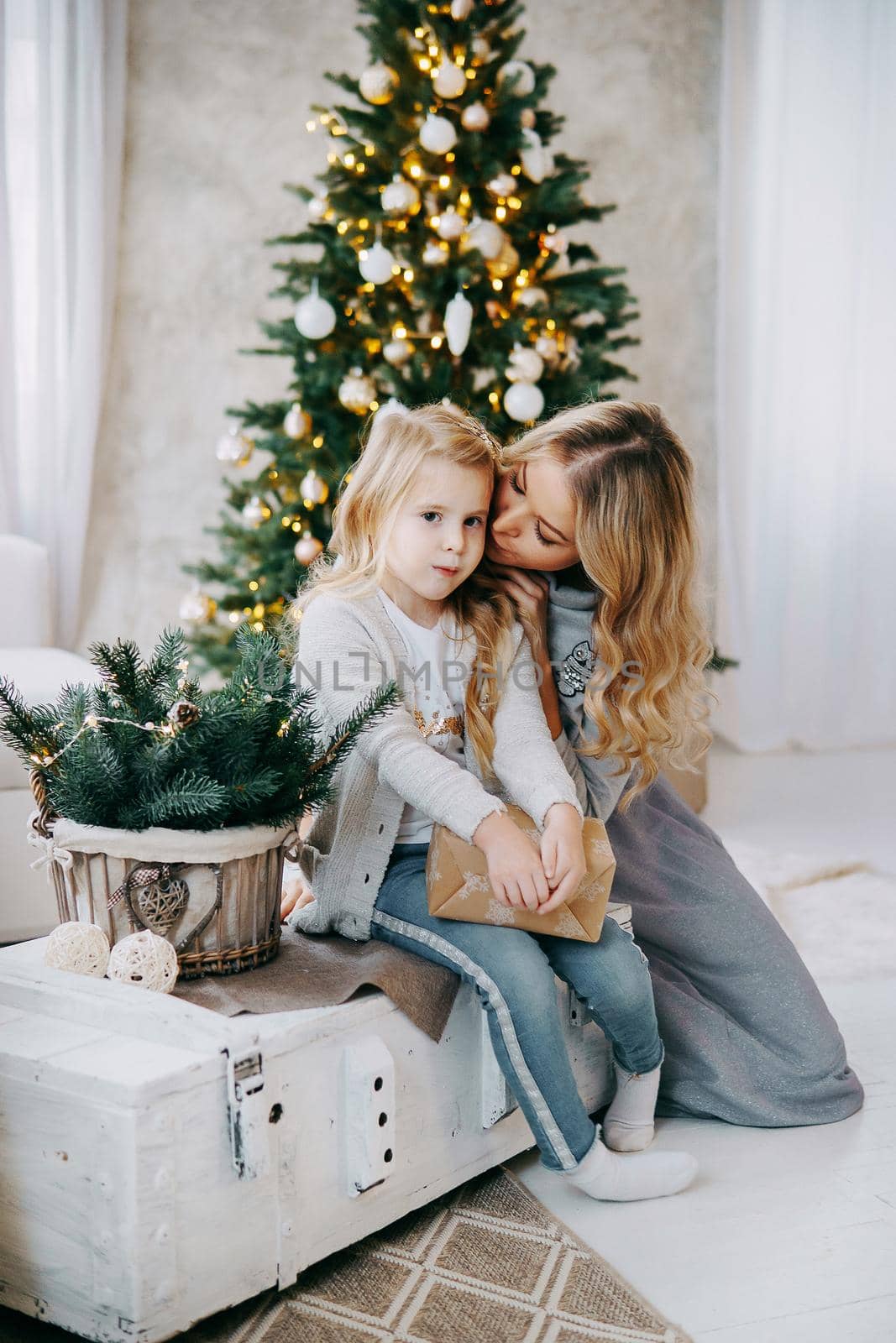 Happy family: mother and daughter. Family in a bright New Year's interior with a Christmas tree.