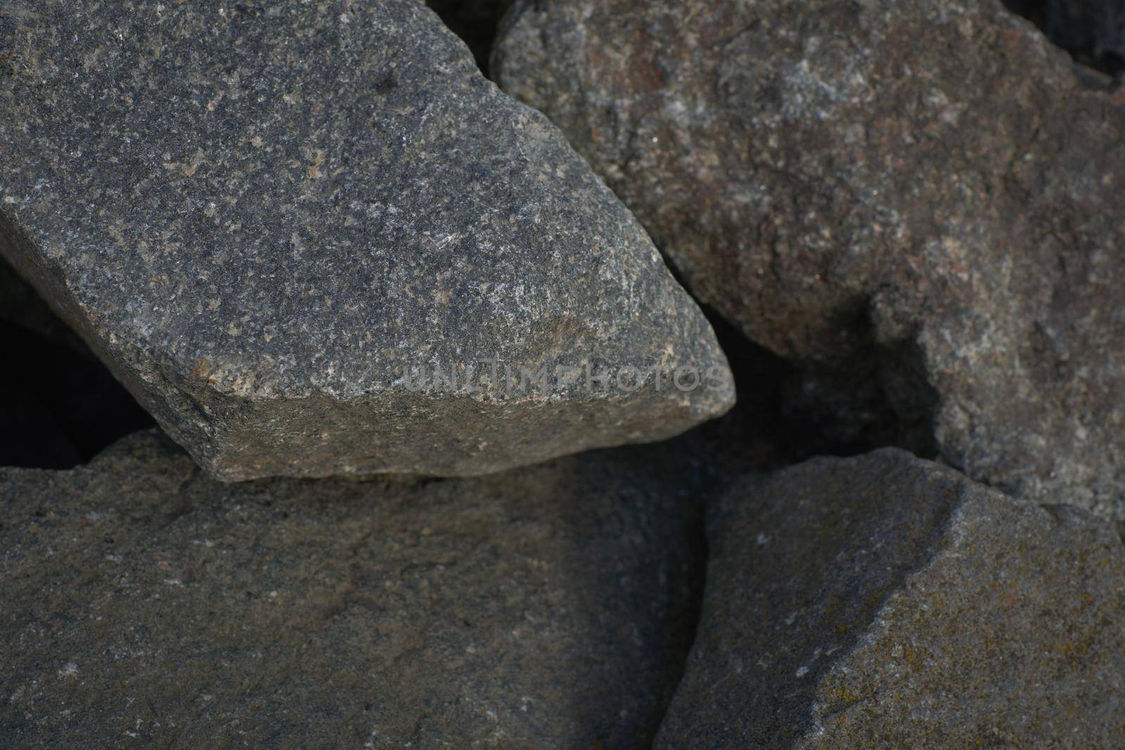 The texture of a large granite cobblestone as a background. Selective focus