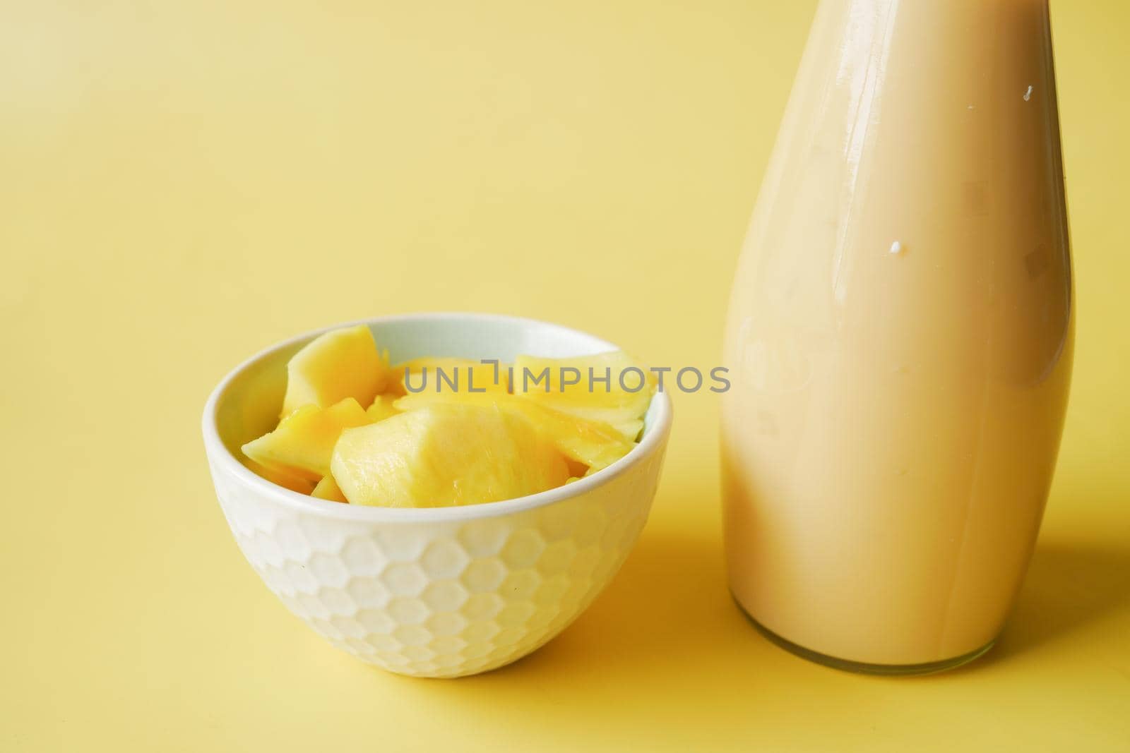 mango smoothie and fresh mango on yellow background ,