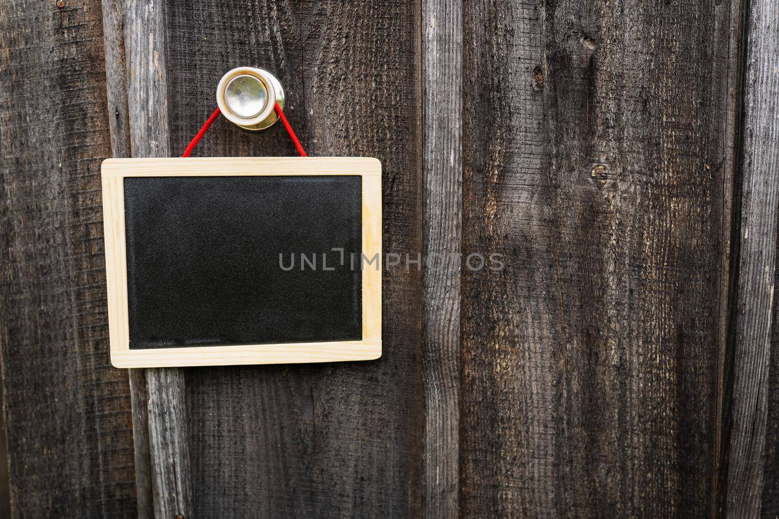 A small graphite note board on a wooden background, a note board, a frame hanging on a pen, a place for an inscription