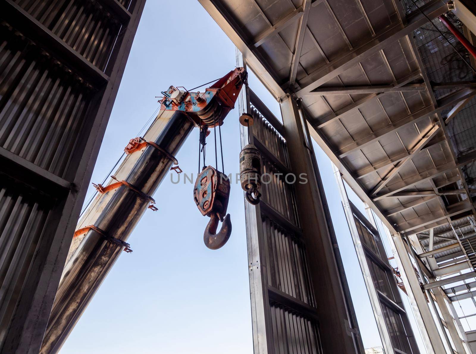 Hoist of crane at the window of industrial plant