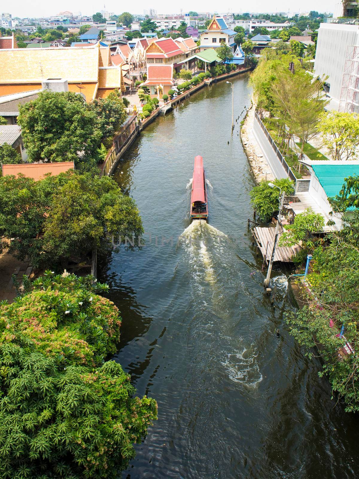 Long-tail passenger boat in Bangkok canal by Satakorn
