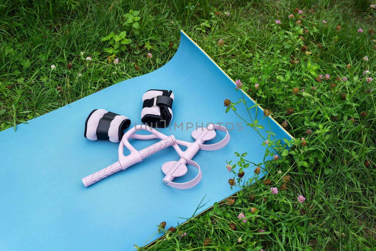 Outdoor activities, yoga mat with weights and massager. Sports in nature outdoors
