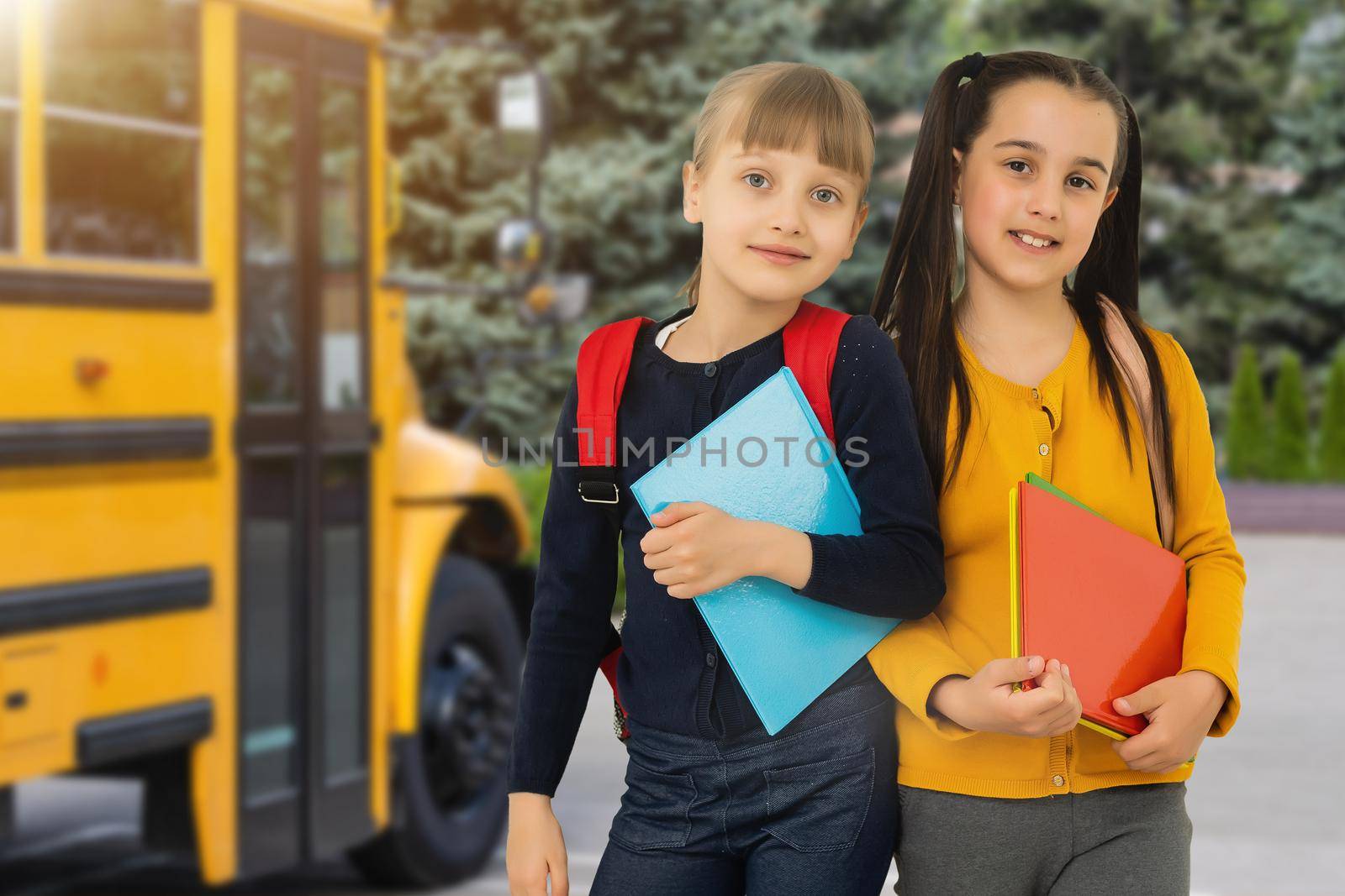 Little kids schoolchildren pupils students, the school bus. Welcome back to school. The new academic semester year start.