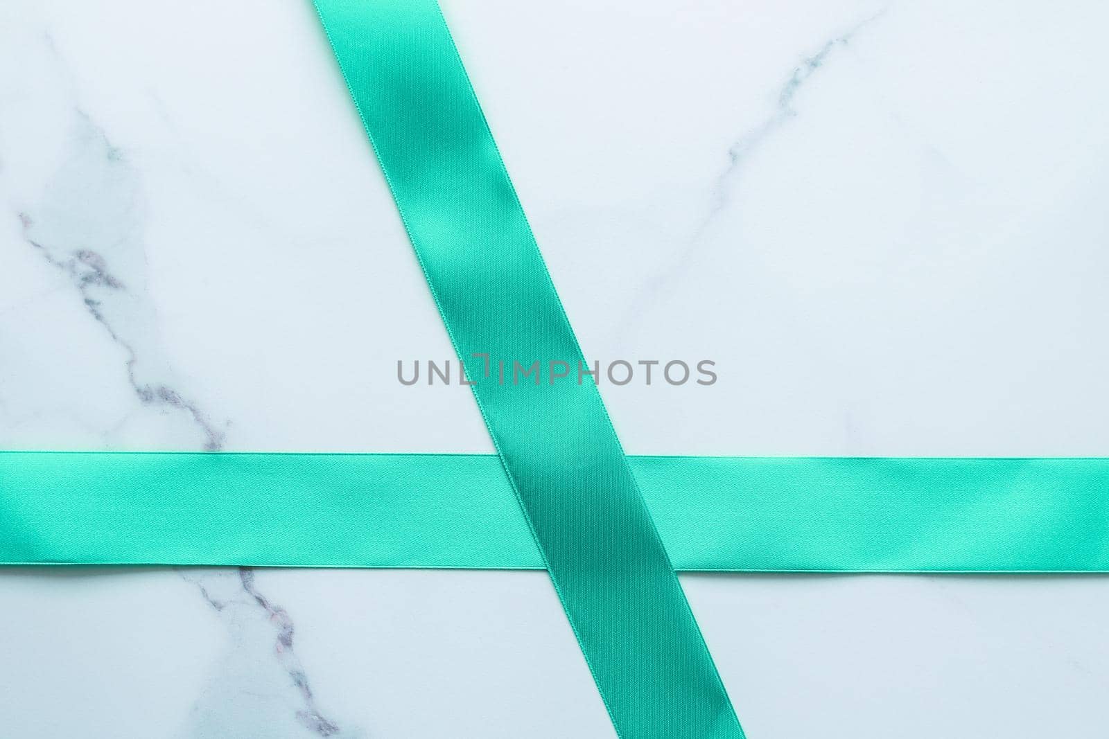 Holiday design, greeting card and vintage gift concept - Green silk ribbon on marble background, top view