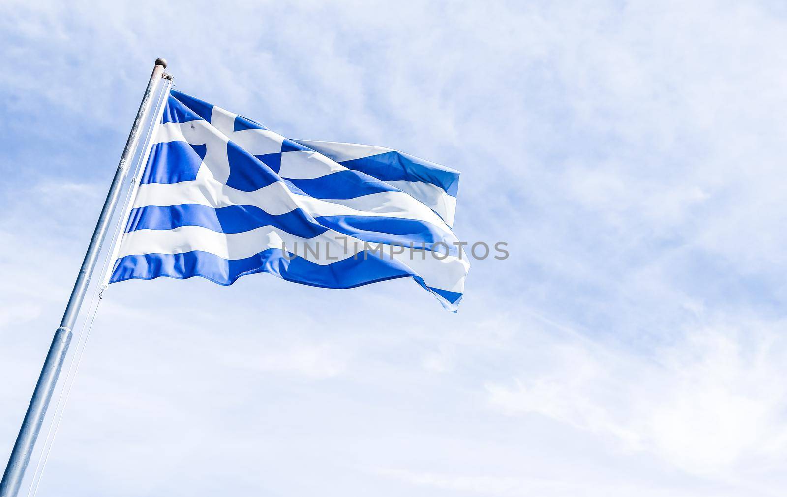 Greek flag and cloudy sky in summer day, politics of Europe by Anneleven