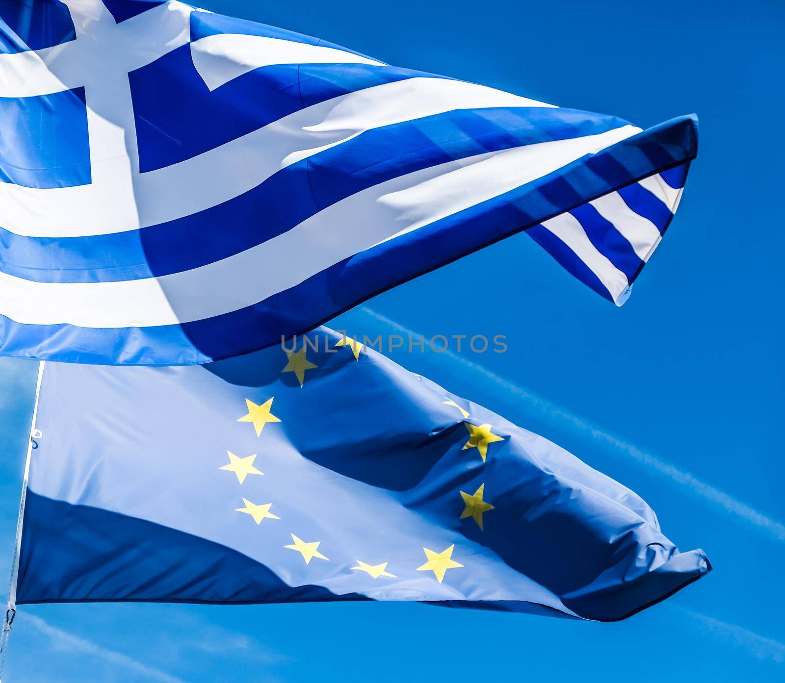 European political news, grexit and nation concept - Flags of Greece and European Union on blue sky background, politics of Europe